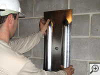 Mounting a foundation wall plate for an earth anchor installation in Portage.