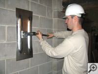 Attempting to straighten a bowed foundation wall by straightening a wall anchor system in a Michigan City home.