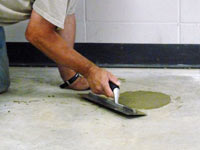 Repairing the cored holes in the concrete slab floor with fresh concrete and cleaning up the Michigan City home.
