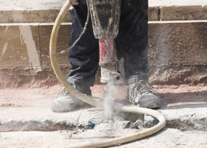 Jackhammering a slab floor in a Crown Point home.