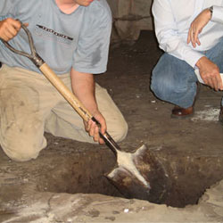 Digging a hole for the engineered fill used in a crawl space support system installation in Goshen