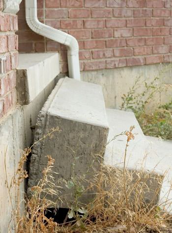 sinking outdoor concrete steps showing cracking and soil washout in Plymouth