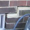 A closeup of a failed tuckpointing job where the brick cracked on a Rochester home.