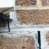 Failed crack repair showing old tuckpointing that cracked on a Gary home.