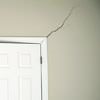 A long drywall crack beginning at the corner of a doorway in a Plymouth home.