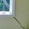 A long, diagonal crack that begins at a window corner of a Highland home