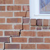 long jagged cracks starting at the corner of a window along a brick wall on a Hammond home