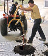 Digging a hole in the garage floor to make room for a wall anchor installation in Schererville, Indiana