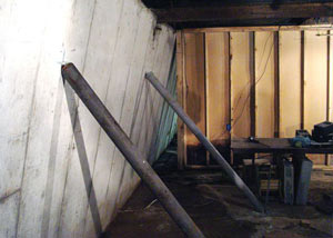 A severely tilting foundation wall propped up by steel beams in Rochester.
