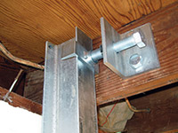 Securing the i-beam system to the top of the floor joist in a foundation wall repair in Michigan City.