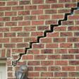 stair step cracking reaching from a window along the foundation wall in Gary