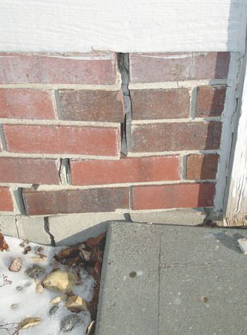 Severe street creep damage to a garage wall outside a Lowell home