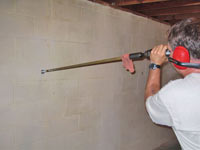 Drilling the hole in the foundation wall for street creep repairs in Columbia City