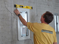 Positioning a wall plate cover on a foundation wall in Goshen.